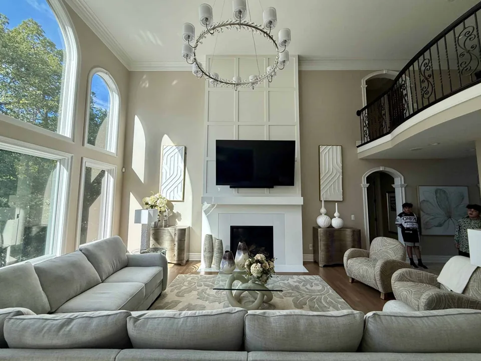 Tall living room with light painted walls, white trim, and arched windows